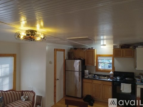 A kitchen with wooden cabinets and a stainless steel refrigerator.