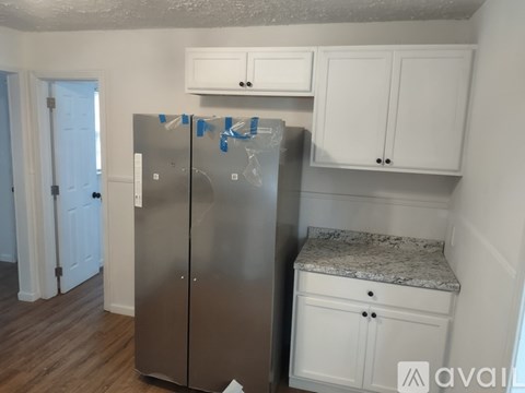 A kitchen with a refrigerator covered in blue painter's tape.