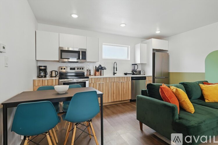 A kitchen with a table and chairs in front of it.