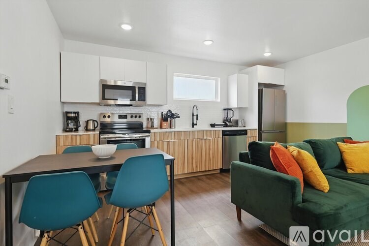 A kitchen with a table and chairs in front of it.