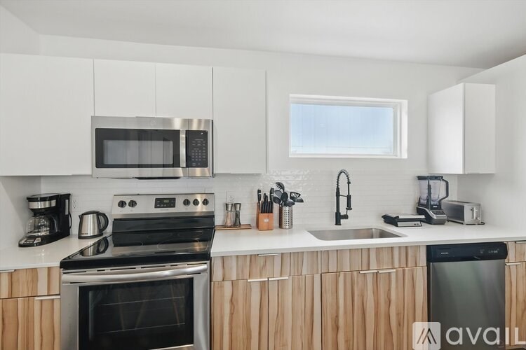 A kitchen with a stove, oven, microwave, and sink.