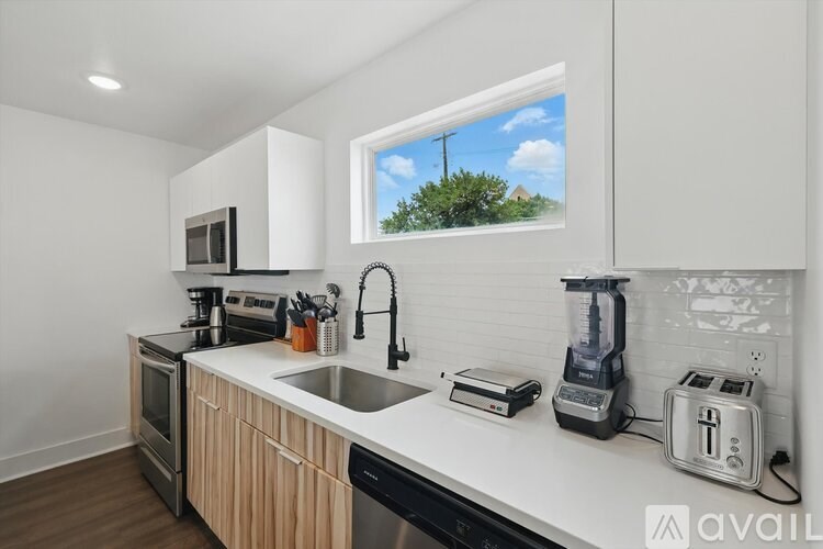A kitchen with white countertops and wooden cabinets.