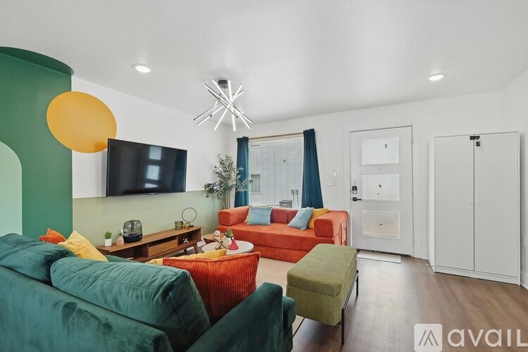 A living room with a green couch and a red couch.