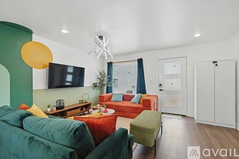 A living room with a green couch and a red couch.