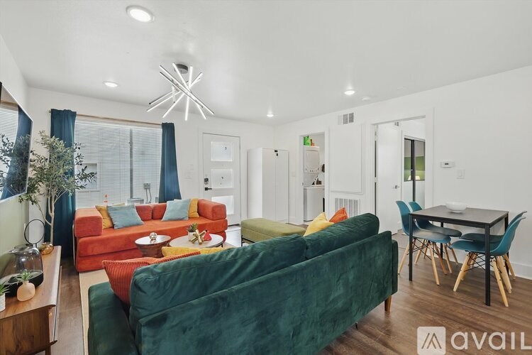 A living room with a green couch and a dining table.