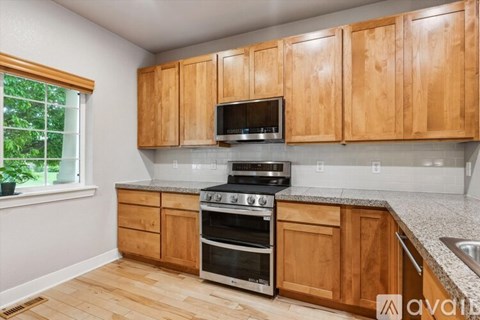 A kitchen with wooden cabinets and a stainless steel oven.