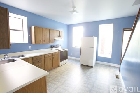 A kitchen with blue walls and wooden cabinets.