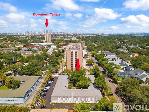 An aerial view of Downtown Tampa with a red arrow pointing to a specific building.