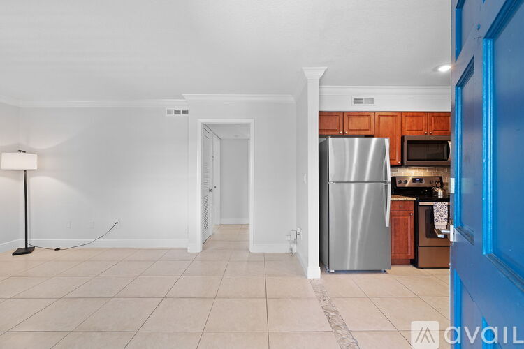 A kitchen area with a refrigerator, microwave, and cabinets.