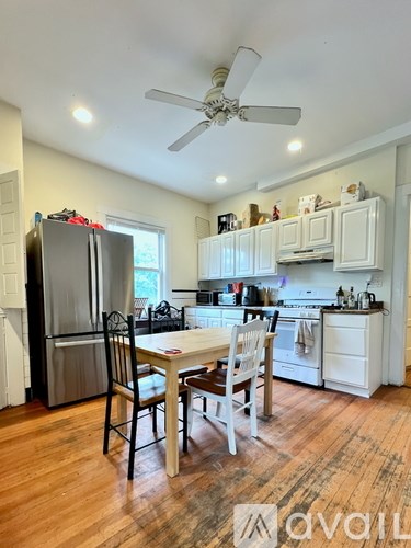 A kitchen with a table and chairs in front of a refrigerator.