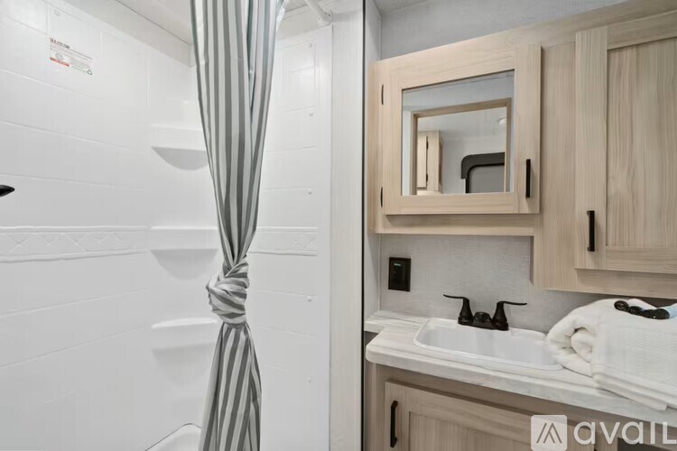 A bathroom with a white sink and a striped curtain.
