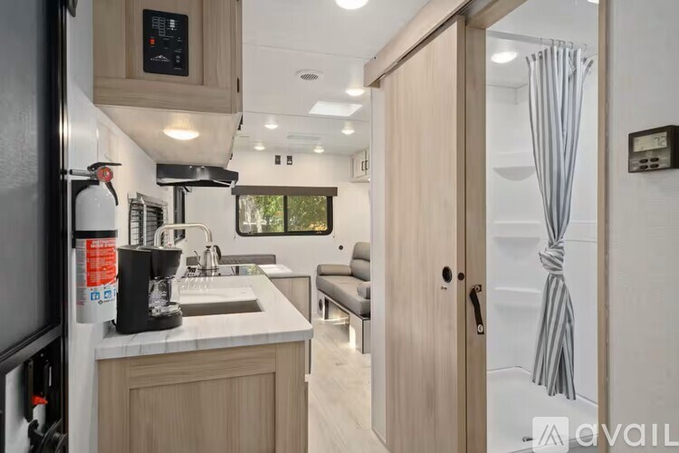 A modern kitchen with a sink, a coffee maker, and a refrigerator.