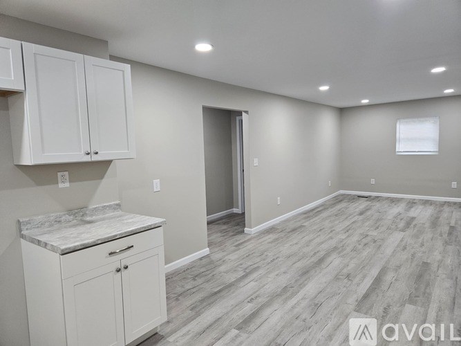 A kitchen area with white cabinets and a marble countertop.