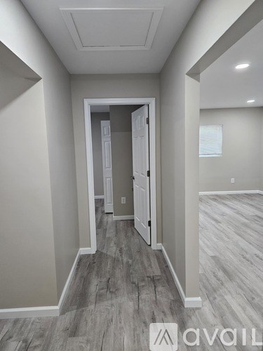A hallway with a doorway leading to another room.