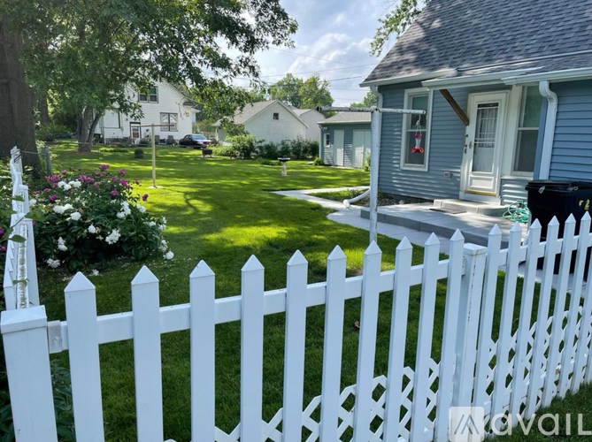 A white picket fence in front of a house.