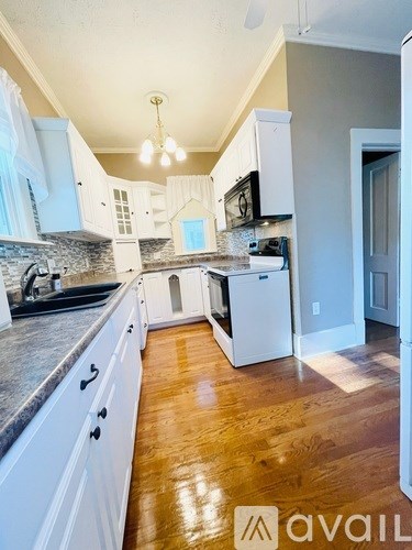 A kitchen with white cabinets and a granite countertop.
