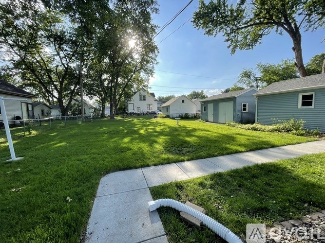 A sunny day in a residential area with houses and green lawns.