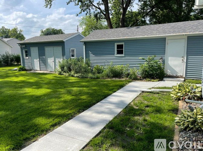 A sunny day at a residential area with two houses and a well-kept lawn.