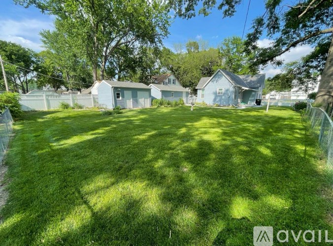 A backyard with a fence and a house in the background.