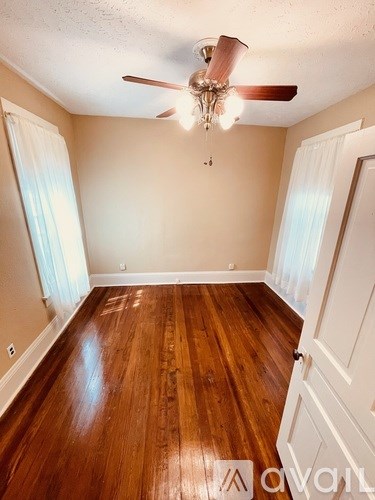A room with wooden floors and a ceiling fan.