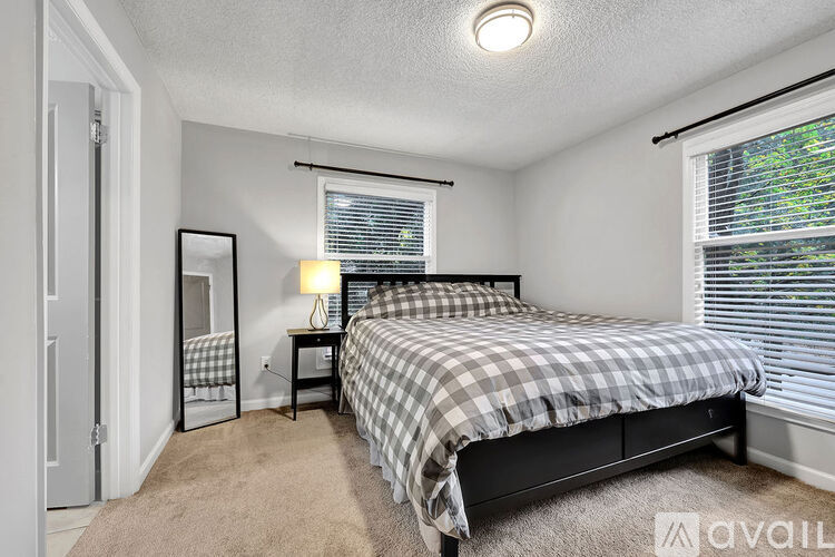 A bedroom with a bed, nightstand, and window.