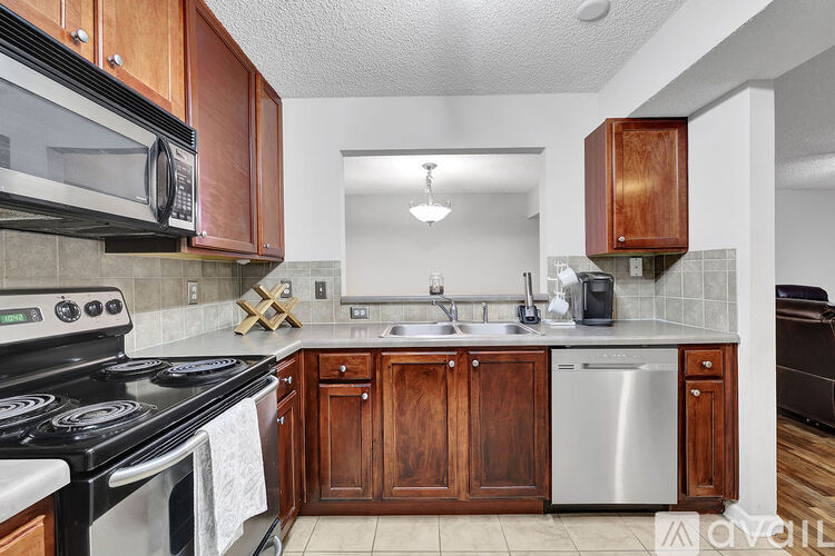 A kitchen with wooden cabinets and a black stove top oven.