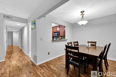 A dining room with a wooden table and chairs.