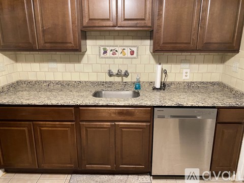 A kitchen with brown cabinets and a granite countertop.