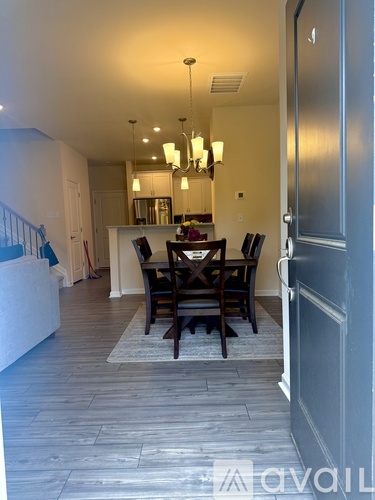 A dining room with a table and chairs is visible through an open door.