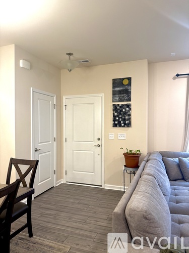 A living room with a grey couch and a wooden chair.