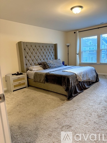 A bedroom with a large bed and a window.