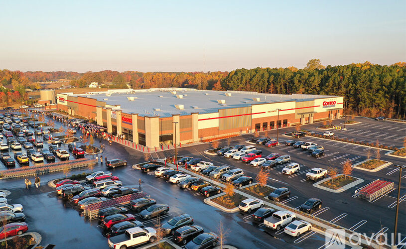 A large parking lot in front of a big building with a lot of cars.