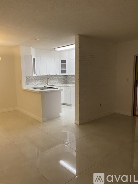 A kitchen with white cabinets and a white island.