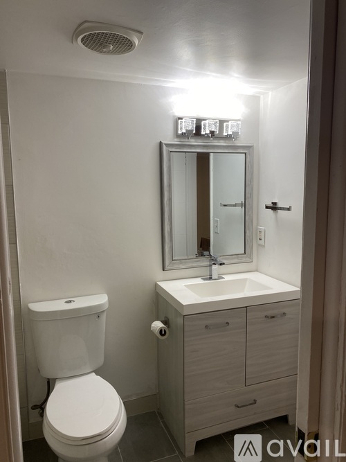 A white toilet sits next to a sink in a small bathroom.