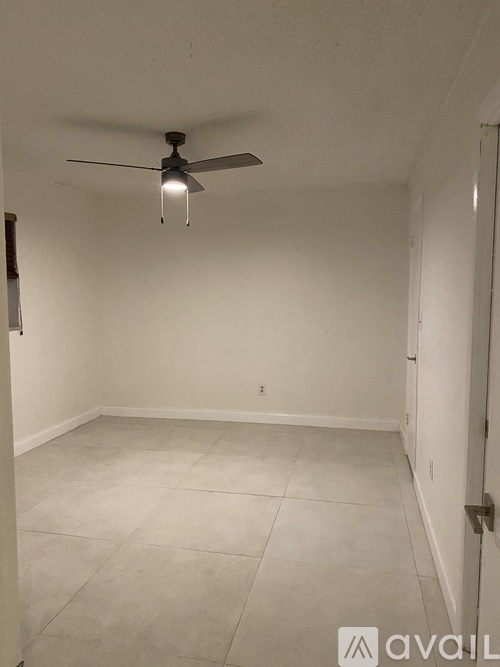 A room with a ceiling fan and tiled floor.