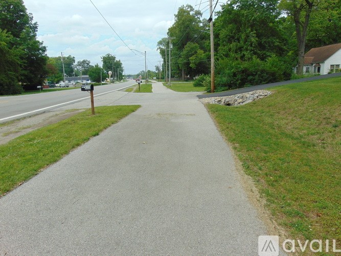 A grassy area with a path leading to a garage.