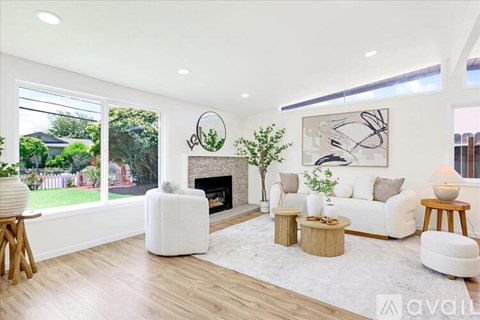 A living room with a fireplace and a painting on the wall.