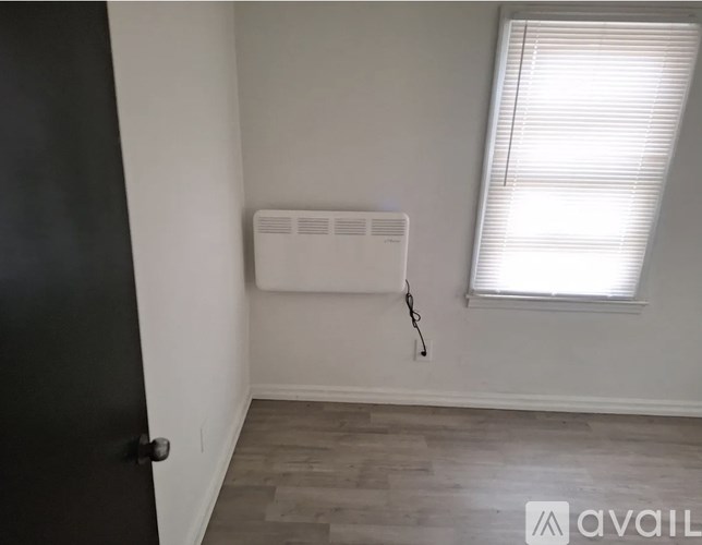 A room with a window and a wall-mounted air conditioner unit.