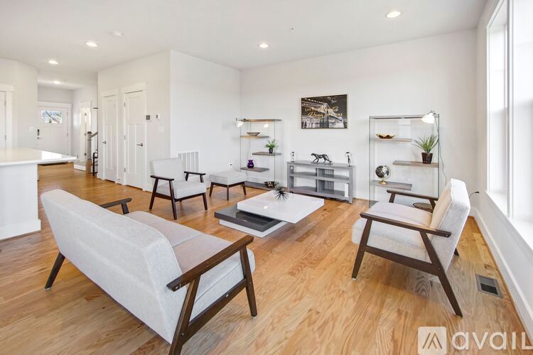 A living room with white furniture and a wooden floor.