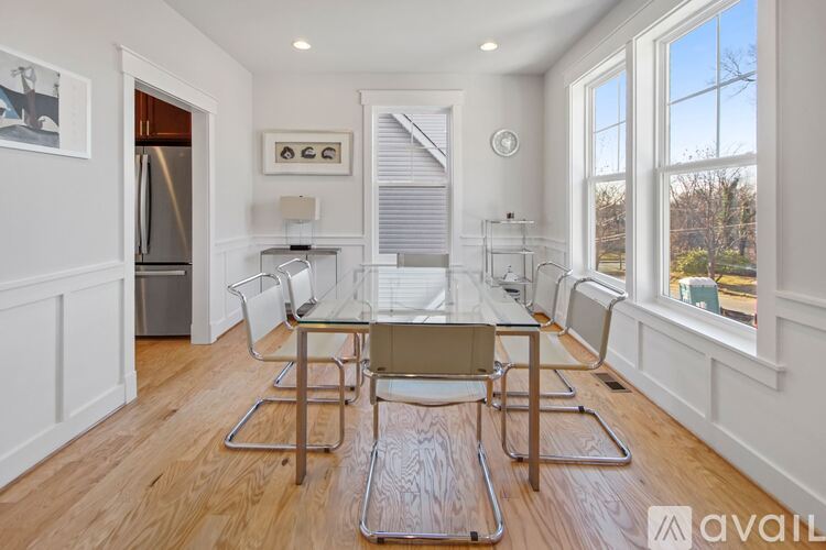 A dining room with a glass table and chairs.