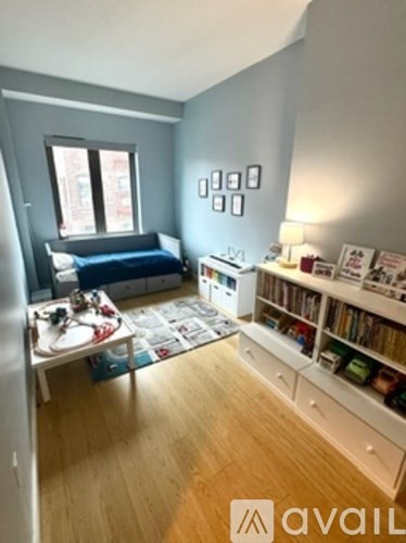 A living room with a blue couch and a bookshelf.