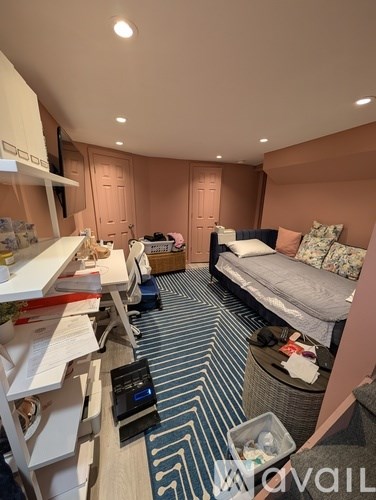 A bedroom with a bed, desk, and chair.