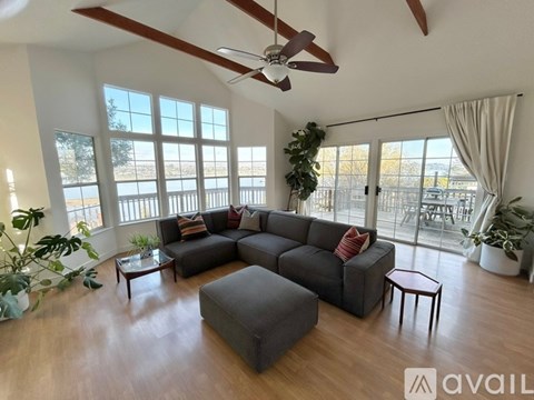 A living room with a grey sofa and a wooden floor.