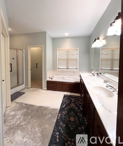 A bathroom with a large mirror, sink, and bathtub.