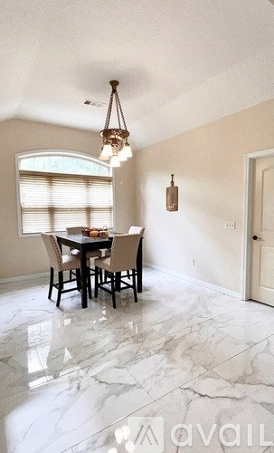 A dining room with a table and chairs.