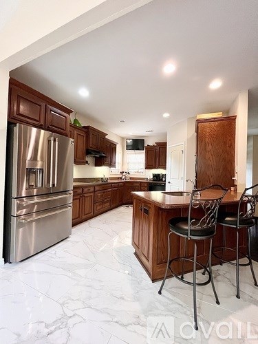 A kitchen with a marble floor and wooden cabinets.