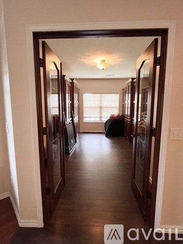 A hallway with a light on the ceiling and a bag on the floor.