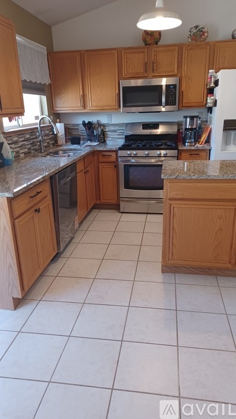 A kitchen with wooden cabinets and a tile floor.