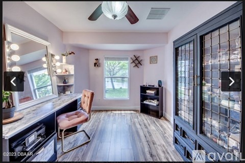 A kitchen with a wooden floor and a ceiling fan.