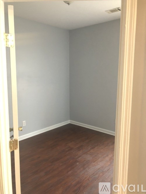 A room with a wooden floor and a white door.